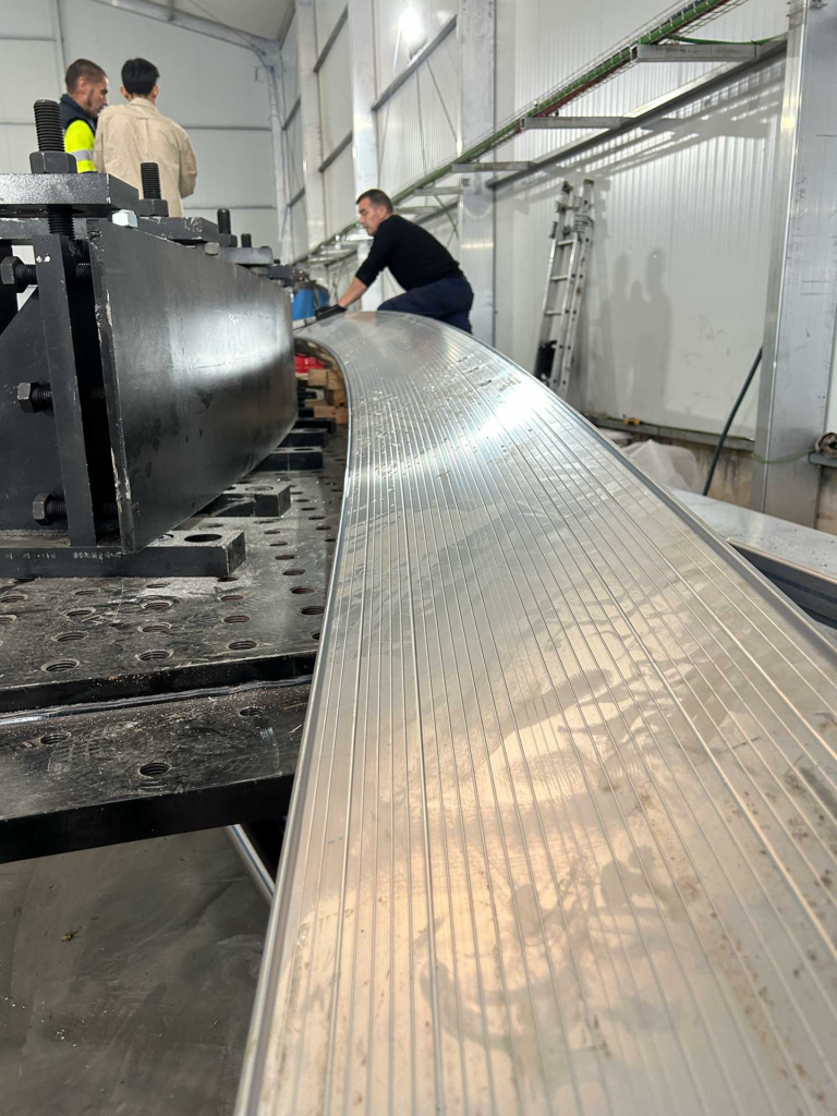 Curvado por estirado de perfiles para carpas modulares