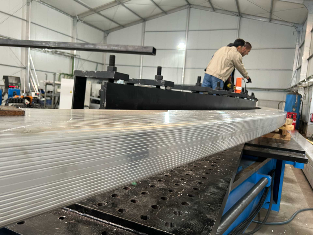 Ingeniero de BIT supervisando a un operador durante el curvado de perfiles de aluminio para carpas y domos